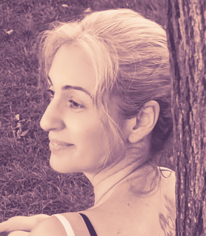 Ana Belén, de perfil y sonriendo, apoyada en un árbol